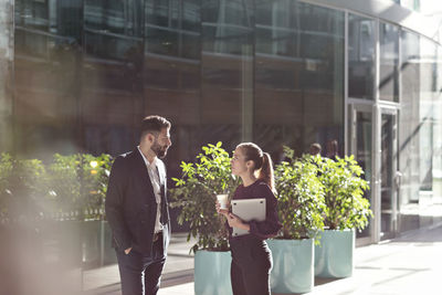 Business colleagues talking while standing in modern office