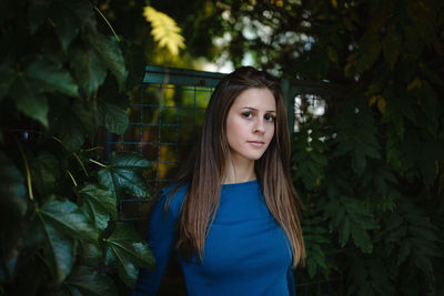 Beautiful young woman  in a blue long sleeve shirt in an autumn park. fall or summer season 