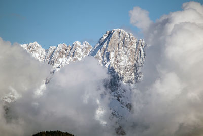 Low angle view of snowcapped mountains against sky