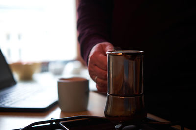 Close-up of hand holding coffee cup