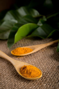 Close-up of turmeric in wooden spoons on table