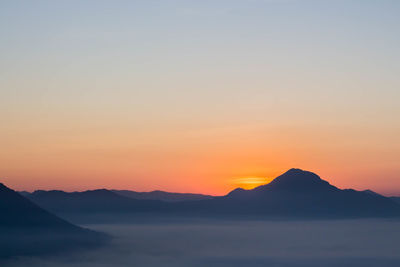 Scenic view of silhouette mountains against sky during sunset