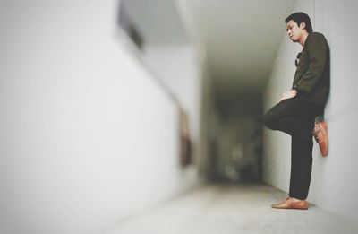 Low angle view of man leaning on wall