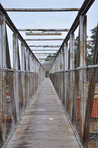 Empty footbridge against sky