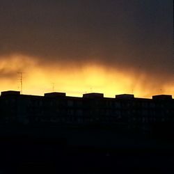 Silhouette of buildings against sky at sunset