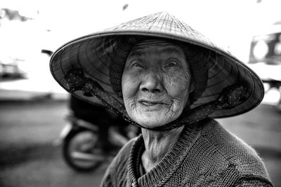 Close-up of senior woman wearing hat making face