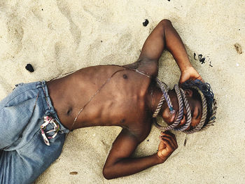 Low section of woman on sand at beach