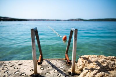 Wooden post in sea against sky