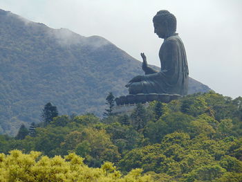 Statue on mountain against sky