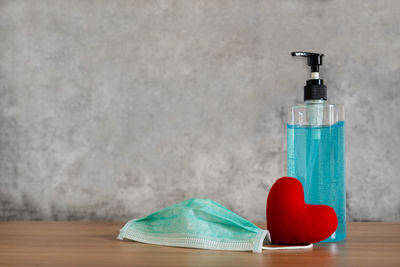 Close-up of glass bottle on table against wall