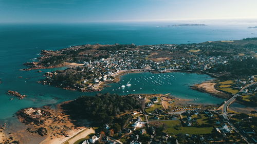 High angle view of city by sea against sky