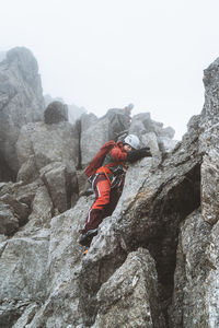 Rear view of man climbing on rock