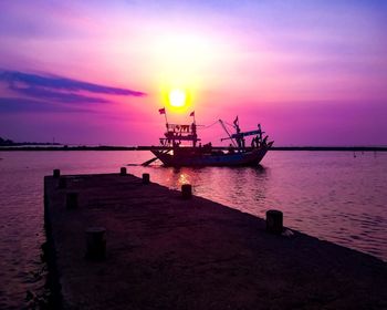 Silhouette boat in sea against sky during sunset