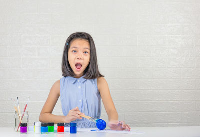 Portrait of girl holding table