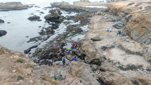 High angle view of people on rocks at shore
