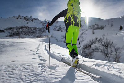 View of people skiing on snowcapped mountain against sky