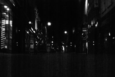 Illuminated street light on road in city at night