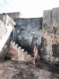 Full length of woman standing in abandoned building