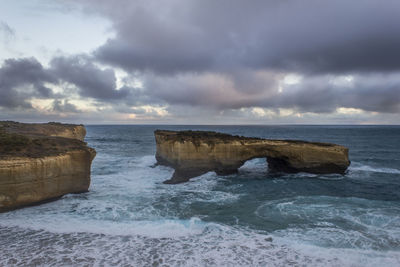 Rock formation in sea at the twelve apostles against cloudy sky