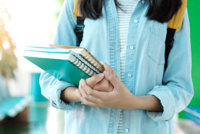 Midsection of woman holding books