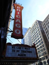 Low angle view of information sign against buildings in city