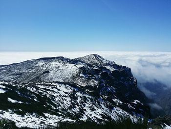 Scenic view of mountains against blue sky