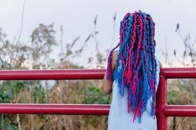 Rear view of woman standing by railing