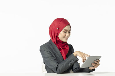 Young woman using phone against white background