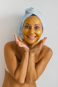 Attractive young adult woman apply face cream, beautiful healthy lady wrapped in towels