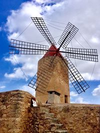 Low angle view of traditional windmill against sky