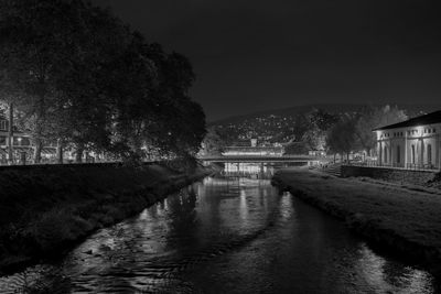 Bridge over river against sky at night