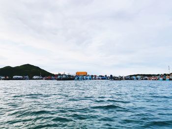 Scenic view of sea by buildings against sky