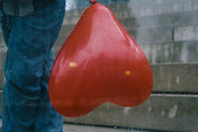 Close-up of wet person holding umbrella during rainy season