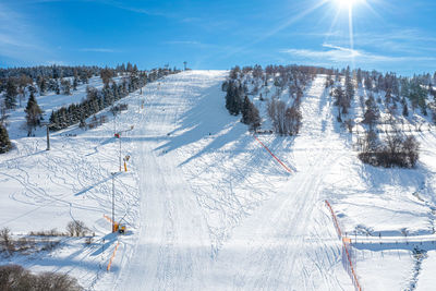 Aerial photo shows an inviting slope for winter sports.  some people are sledding with the toboggan.