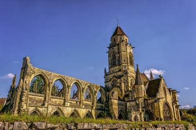 Low angle view of clock tower against blue sky