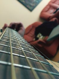 Close-up of playing guitar at home