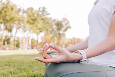 Close-up of woman in the lotus pose. doing yoga outdoors, mindfulness, healthy lifestyle