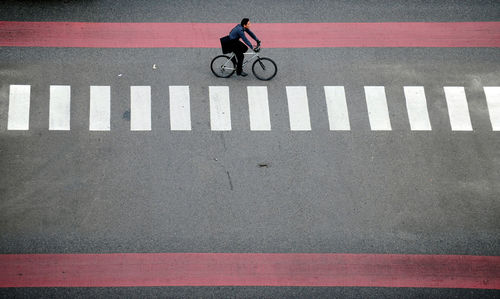 Man riding bicycle on road in city