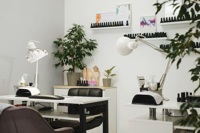 Manicure salon. nail polish for manicure locating on long shelves in green beauty salon. cozy plants