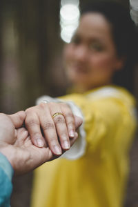 Midsection of couple holding yellow hands