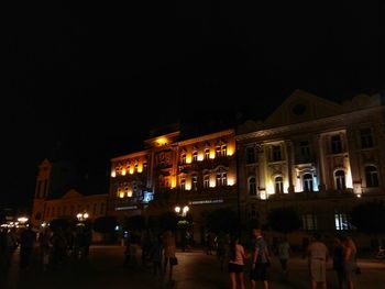 People on illuminated building at night