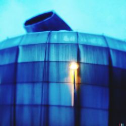 Low angle view of illuminated lamp against blue sky