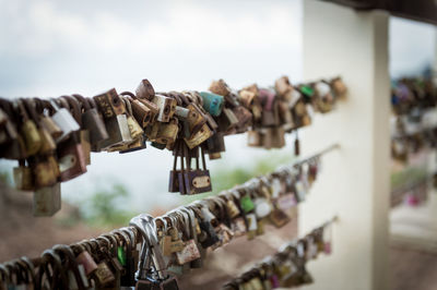 Padlocks on railing of bridge against clear sky