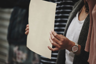 Midsection of woman holding placard