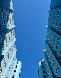 Low angle view of modern buildings against clear blue sky