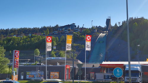 Cars on road against blue sky in city