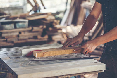 Carpenter cutting wood in workshop