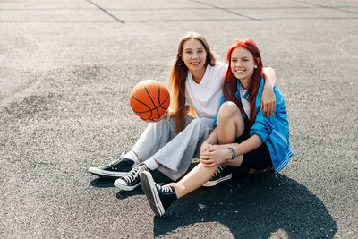 A couple of teenage girls on a sports street court with a basketball lifestyle 