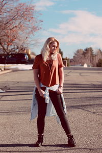 Portrait of smiling young woman against sky