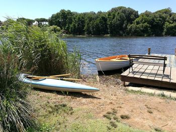 Boat moored in lake against trees